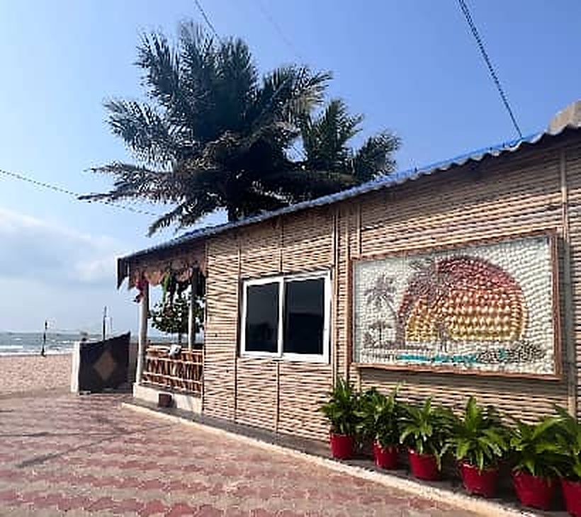 Beachfront cottage with a mosaic sunset artwork and potted plants