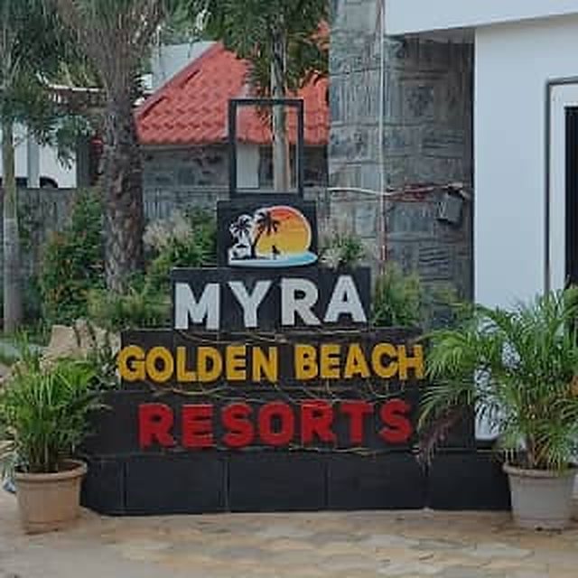 Myra Golden Beach Resort entrance sign surrounded by palms and plants